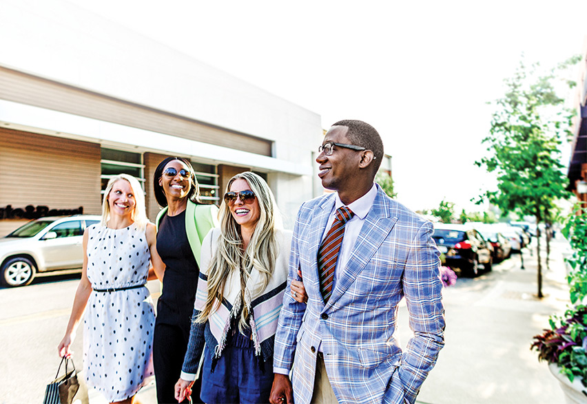 Group of young professionals strolling down a shopping street