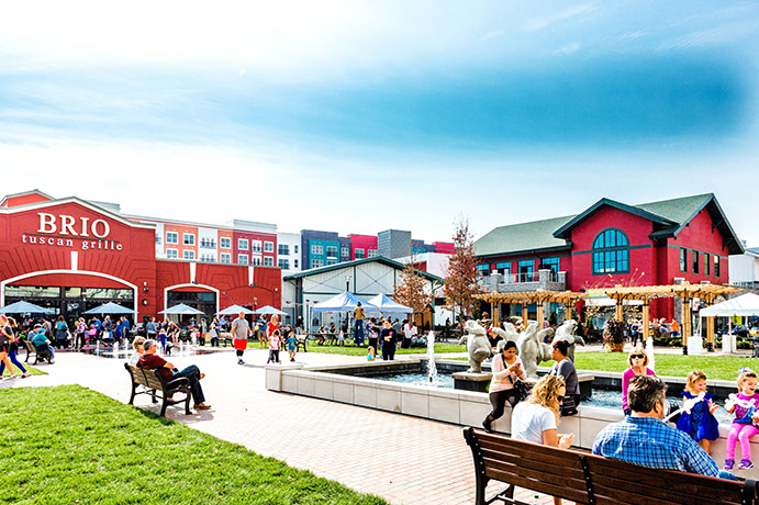 People enjoying a nice day in the courtyard in front of Brio restaurant under a bright blue sky