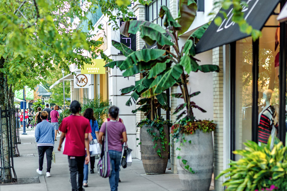 Shoppers walking down the sidewalk about shops at Easton