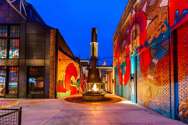 Alley with a heater in the middle and an art mural on one wall
