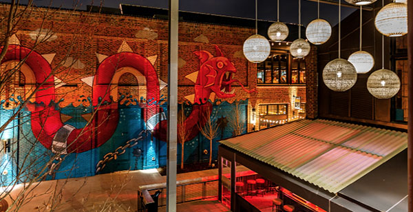 Bright, large swimming sea creature painted on two-story building wall.