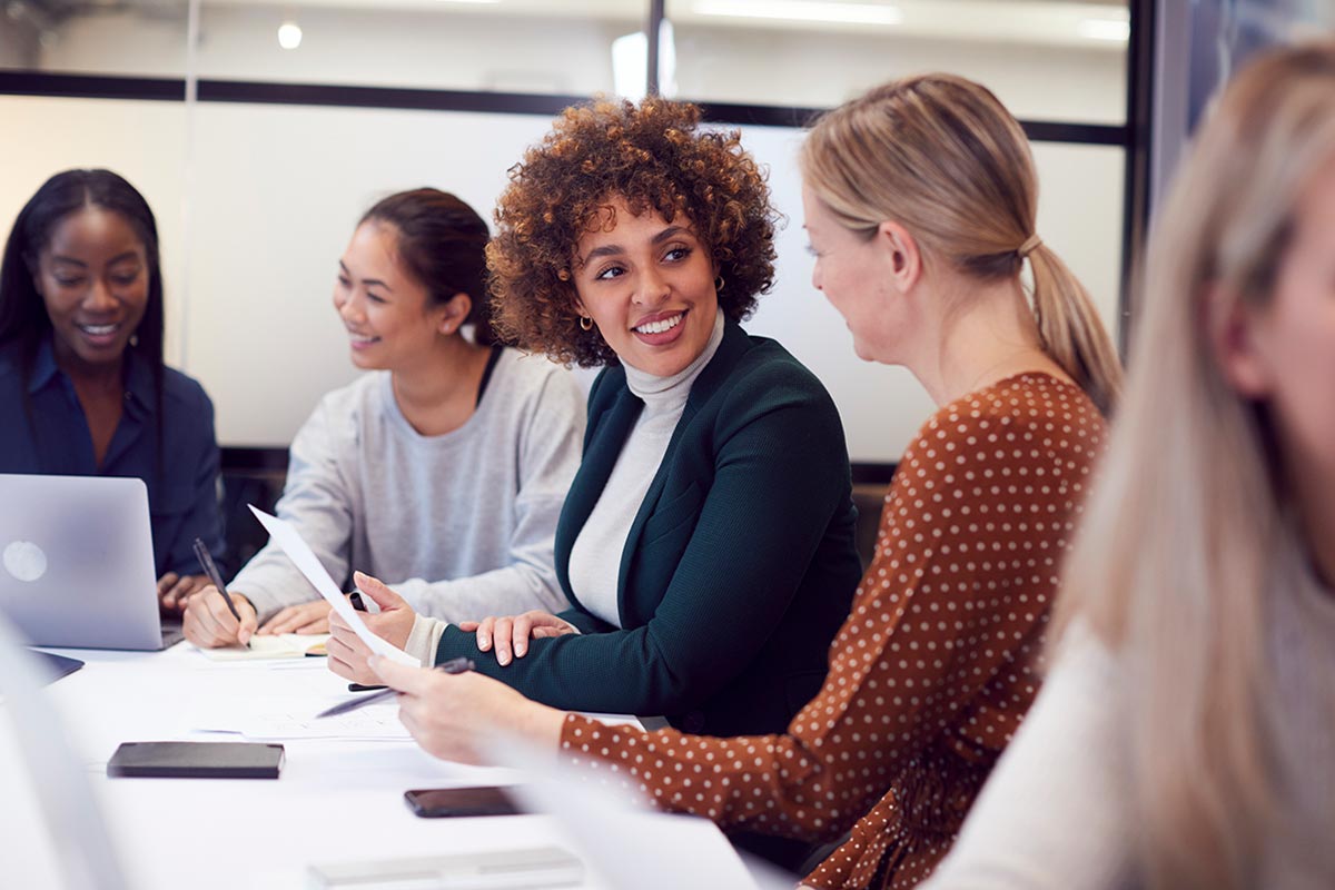 Professional women gathered around conference table