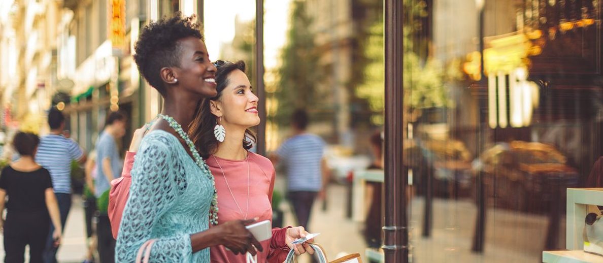 Two women window shopping from the sidewalk